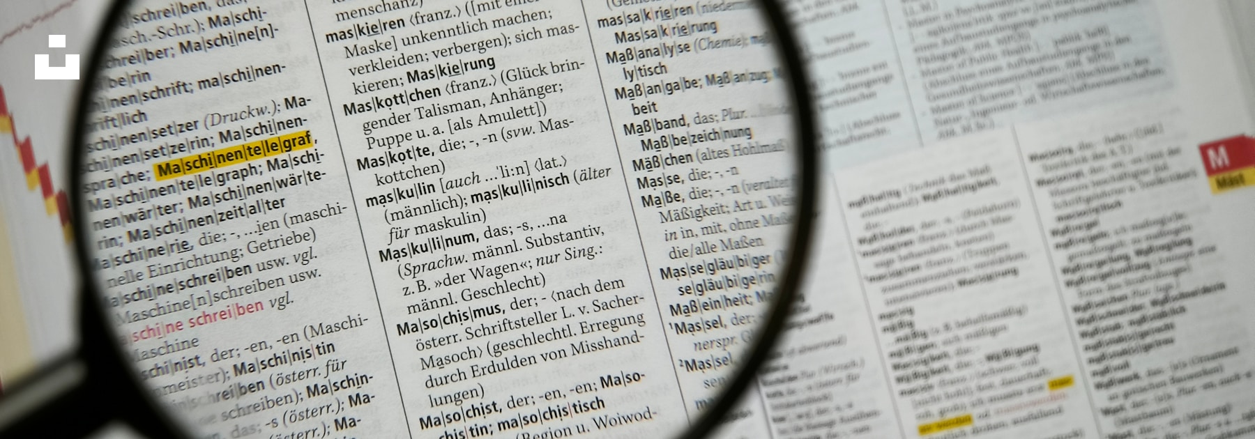 A magnifying glass bringing one region of a dictionary page into sharper focus.